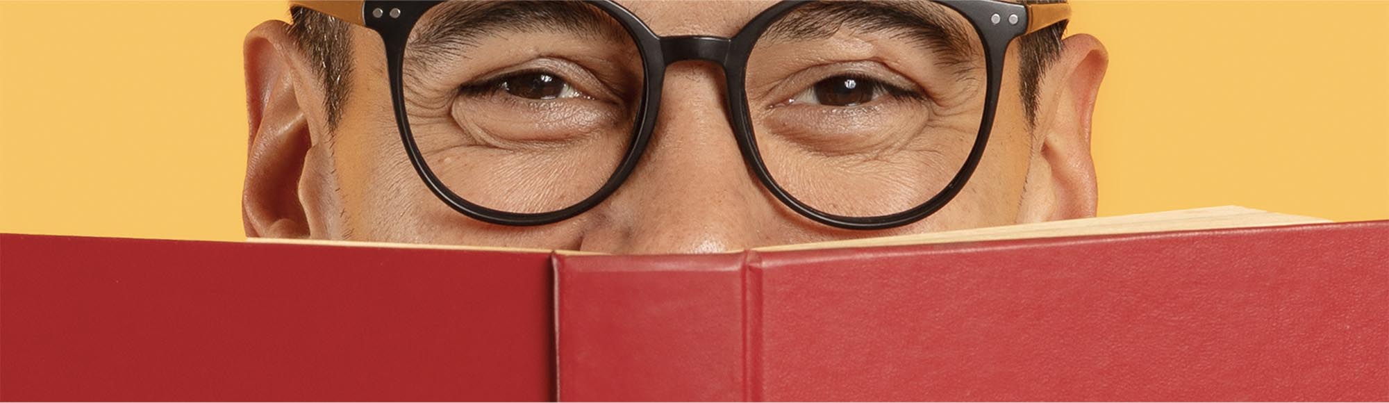 a person reading a book with an excited, wide-eyed look