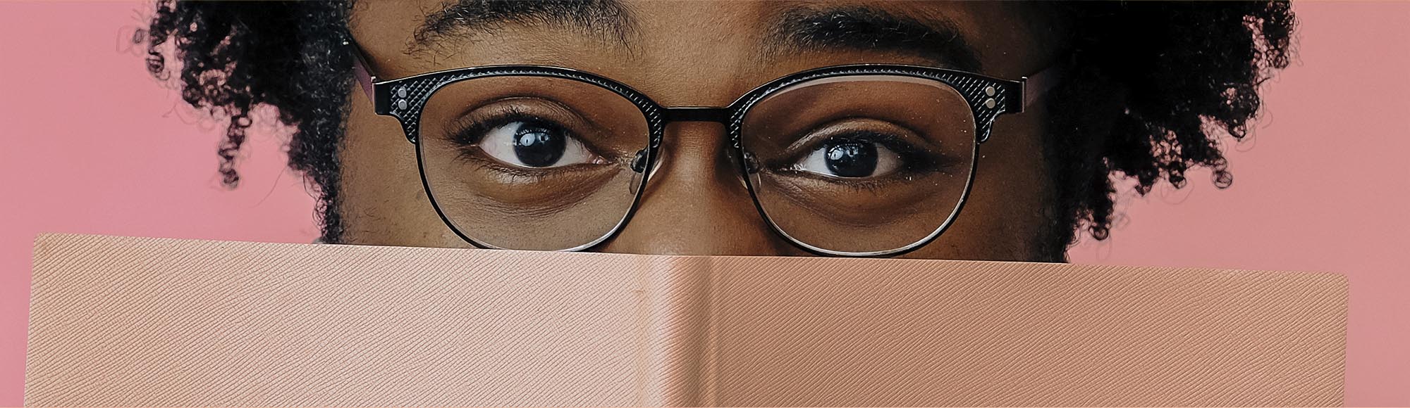 a person reading a book with an excited, wide-eyed look